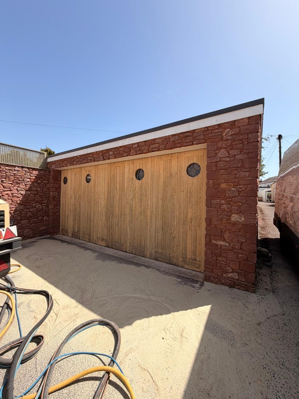 Restored oak garage doors in a sandstone outbuilding